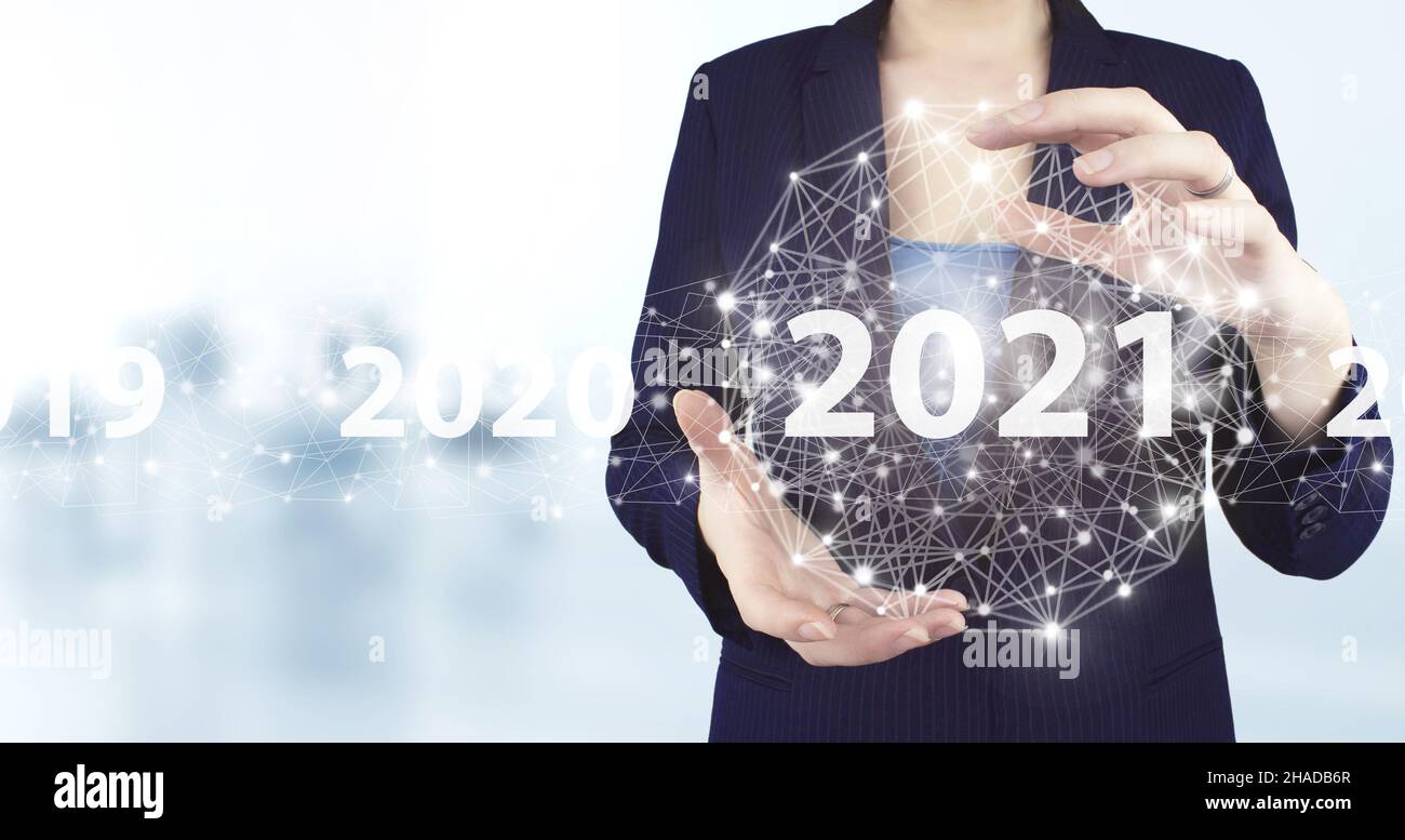 Concept inizio nuovo anno 2021. Icona olografica 2021 virtuale con due mani con sfondo sfocato chiaro. Concetto per Vision 2021. Uomo d'affari welcom Foto Stock