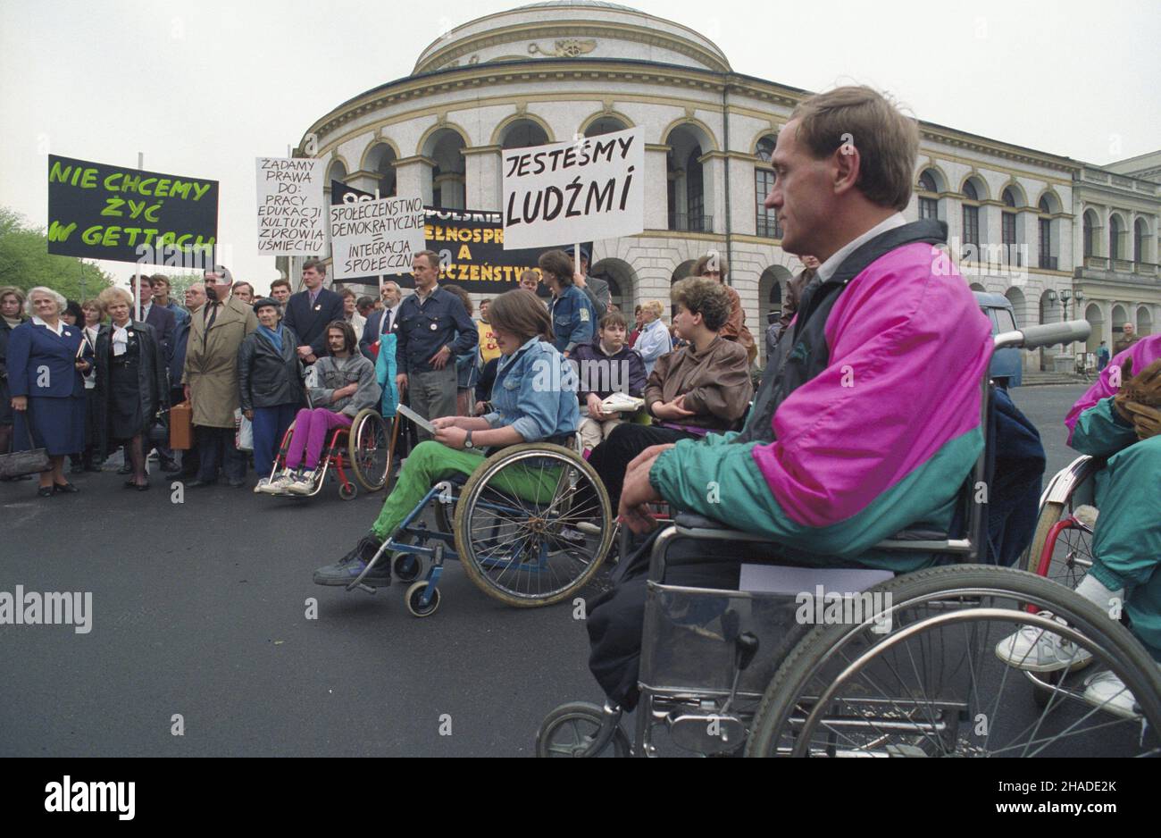 Warszawa 07.05.1992. Ogólnopolskie Foro pt. Niepe³nosprawni a spo³eczeñstwo (7-10 maja 1992), w Warszawskim Oœrodku Kultury przy ulicy Elektoralnej 12. Uczestnicy i goœcie przeszli na plac Bankowy, gdzie odczytany zosta³ protesta przeciwko pogarszaj¹cym siê warunkom ¿ycia niepe³nosprawnych w Polsce. W g³êbi budynek dawnego Banku Polskiego i Gie³dy na rogu placu Bankowego i ulicy Elektoralnej. wb PAP/Janusz Mazur Varsavia 07 maggio 1992. Il Disabled Versus Society National Forum ha organizzato una protesta a Varsavia (7-10 maggio 1992). Dal forum al Warsaw Culture Center al 12 Elektoralna Stree Foto Stock