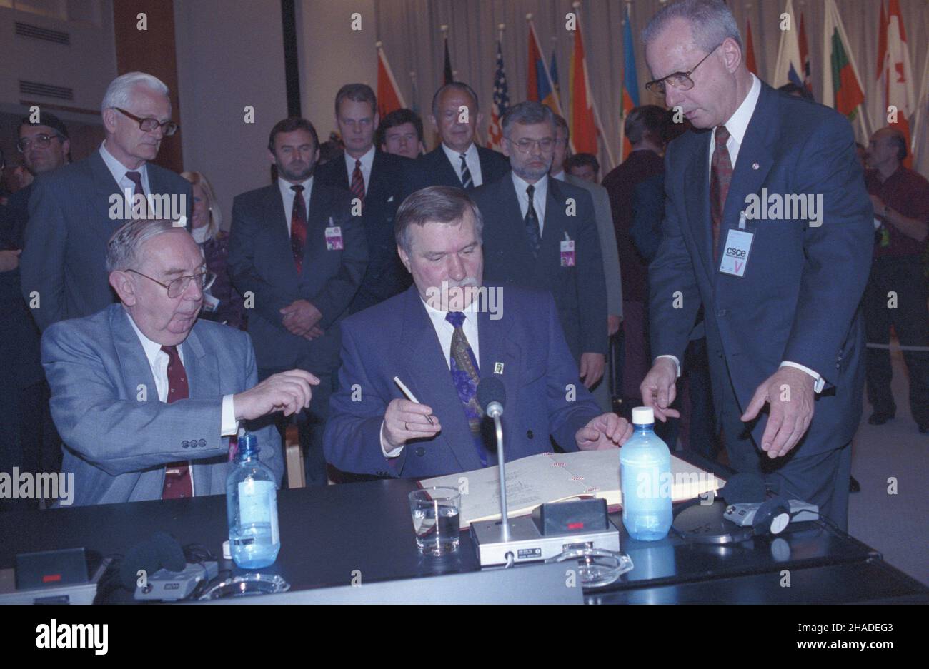 Finlandia Helsinki 10.07.1992. Szczyt Konferencji Bezpieczeñstwa i Wspó³pracy w Europie (KBWE) (9-10 lipca 1992). prezydent RP Lech Wa³êsa (C) i Minister spraw zagranicznych Krzysztof Skubiszewski (L) podpisuj¹ dokument koñcowy pt. Wyzwania czasu przemian. Za nimi stoj¹ m.in. Szef Kancelarii Prezydenta RP Janusz Zió³kowski (2L,siwy), szef Gabinetu Prezydenta RP Mieczys³aw Wachowski (3L), szef protoko³u dyplomatycznego Janusz Œwitkowski (4L)rzecznik prasowy Prezydenta Andrzej Drzycimski RP (wb/6L) Helsinki, Finlandia, 10 luglio 1992. Presidente della Polonia Lech Wale Foto Stock