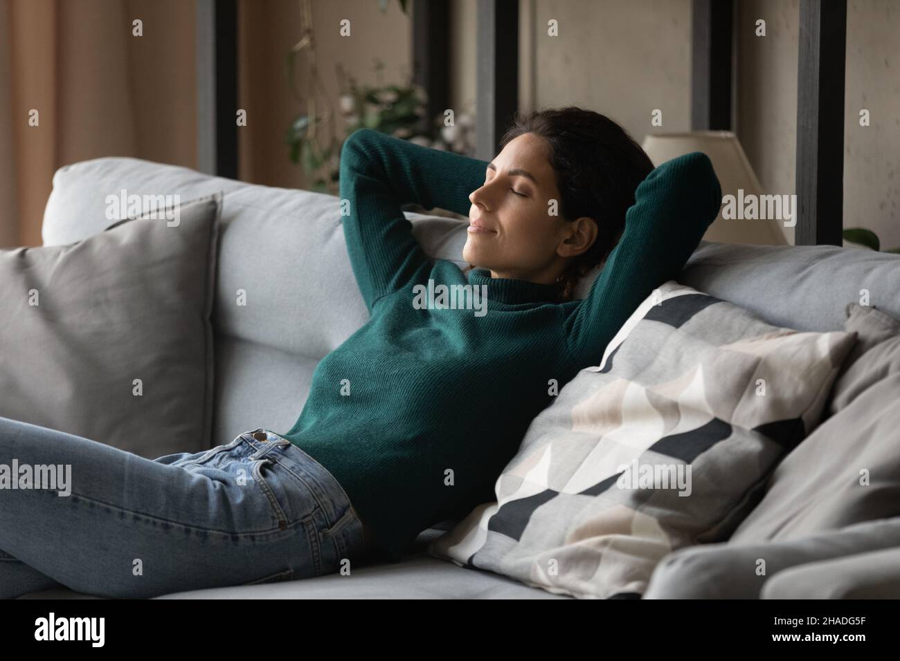 Calma donna ispanica rilassarsi sul divano letto Foto Stock