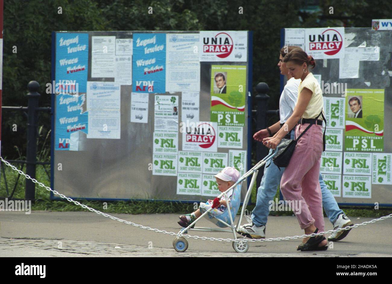 Wroc³aw 15.08.1993. Rodzina na spacerze. W g³êbi plakaty wyborcze, rozklejane na ulicach miasta w ramach kampanii przed jesiennymi wyborami do parlamentu. mta PAP/Adam Hawa³ej Breslavia 15 agosto 1993. Una famiglia che si prende una passeggiata. Sullo sfondo i manifesti elettorali prima di un'elezione parlamentare autunnale. mta PAP/Adam Hawalej Foto Stock