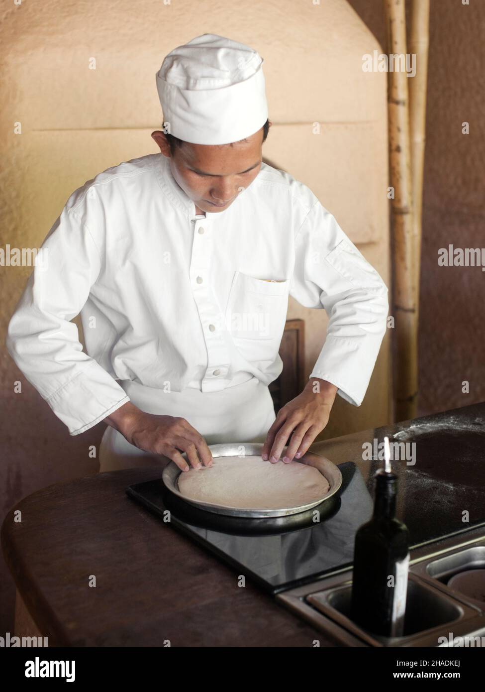 Uno chef prepara una pizza alla cucina a vista di Six Senses Hideaway Yao noi. Thailandia. Foto Stock