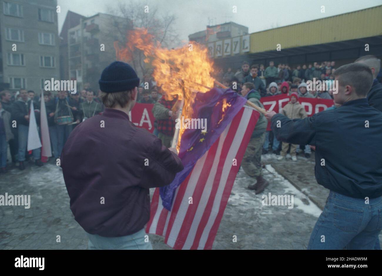 Lubin 26.02.1994. Demonstracja cz³onków i sympatyków nacjonalistycznej partii politycznej Polska Wspólnota Narodowa z udzia³em jej przewodnicz¹cego Boles³awa Tejkowskiego. NZ. Manifestanti na skwerze przed pawilonem handlowym Bazyl przy alei Niepodleg³oœci i ulicy Armii Krajowej pal¹ flagi amerykañsk¹ i Unii Europejskiej. wb PAP/Adam Hawa³ej Lubin, Polonia, 26 febbraio 1994. I manifestanti bruciano bandiere americane ed europee durante una manifestazione politica nazionalista della Comunità nazionale polacca a Lubin. PAP/ADAM HAWALEJ Foto Stock