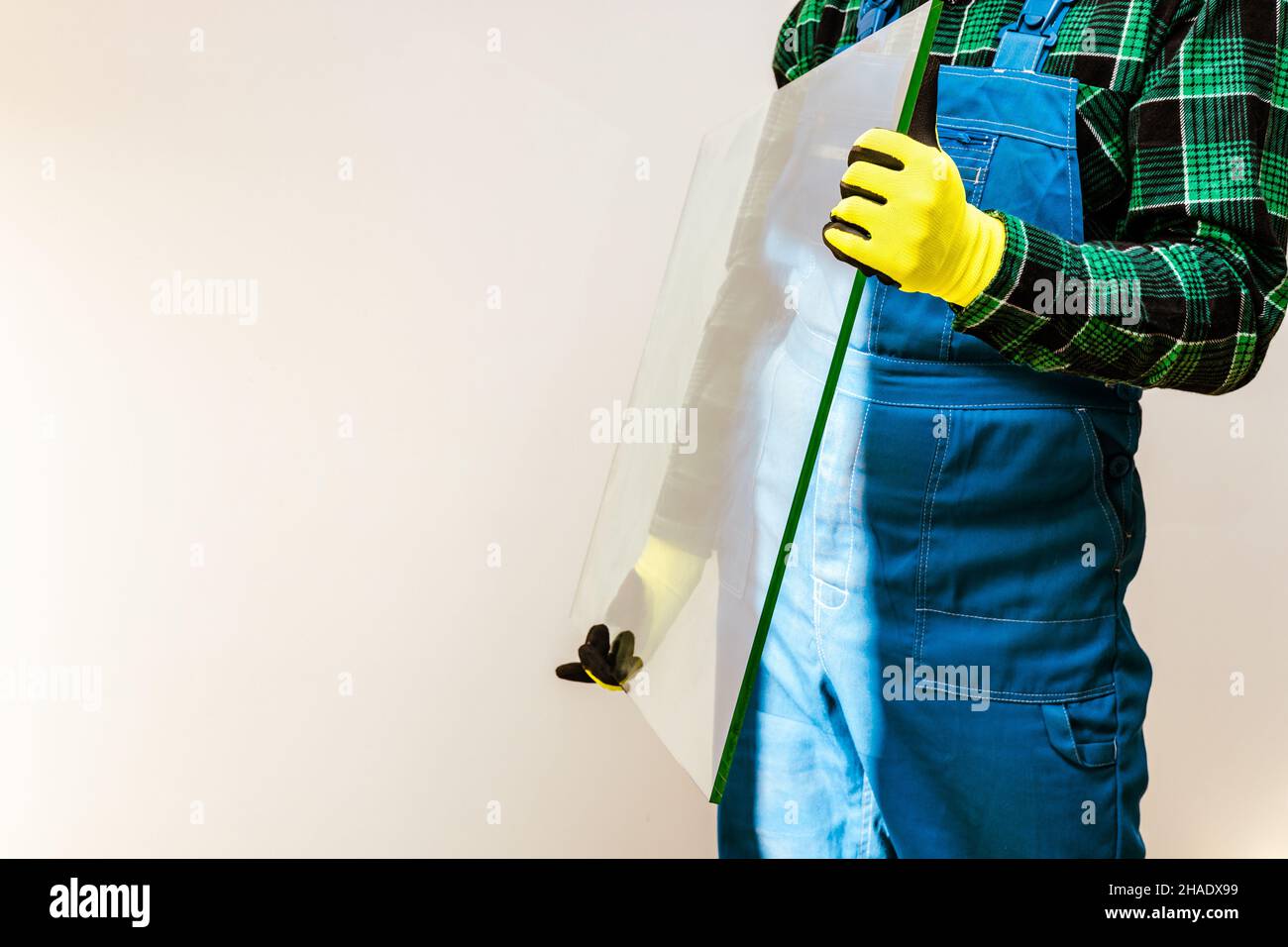 Glazier che tiene nelle sue mani un pezzo di vetro spesso, molto spazio per il testo Foto Stock