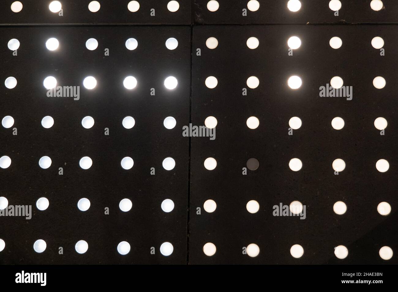 Il LED astratto bianco brillante illumina i punti sul marciapiede esterno, sfondo ad alto contrasto. Foto Stock