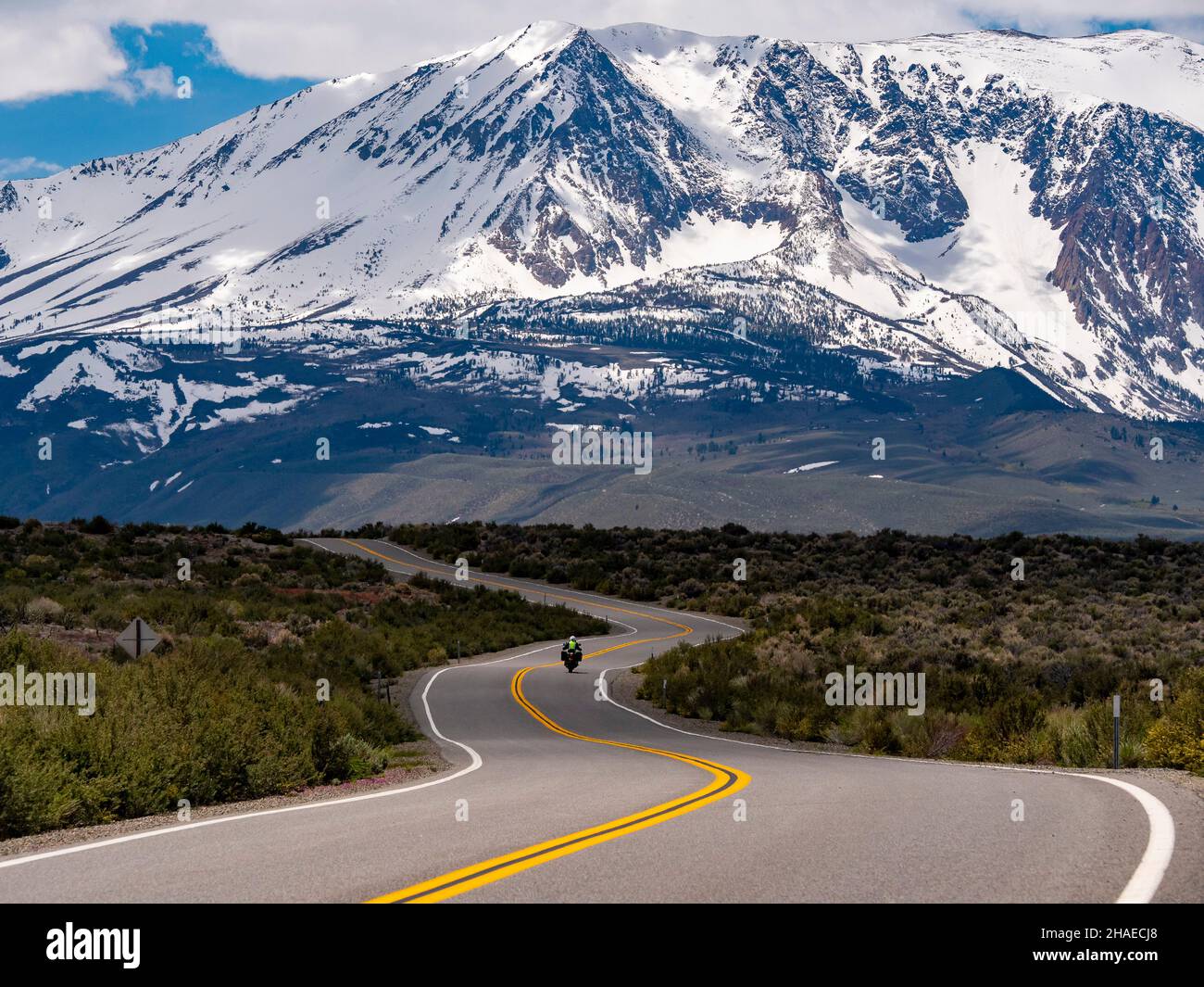Tour in motocicletta sulla strada del bacino del Lago Mono con la catena montuosa della Sierra sullo sfondo Foto Stock