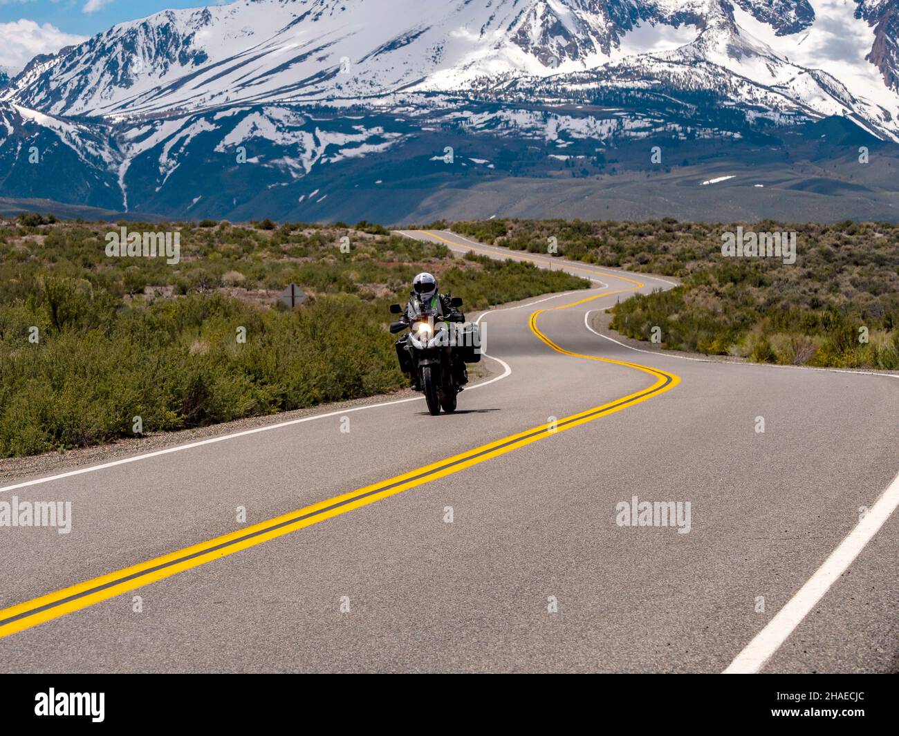 Tour in motocicletta sulla strada del bacino del Lago Mono con la catena montuosa della Sierra sullo sfondo Foto Stock