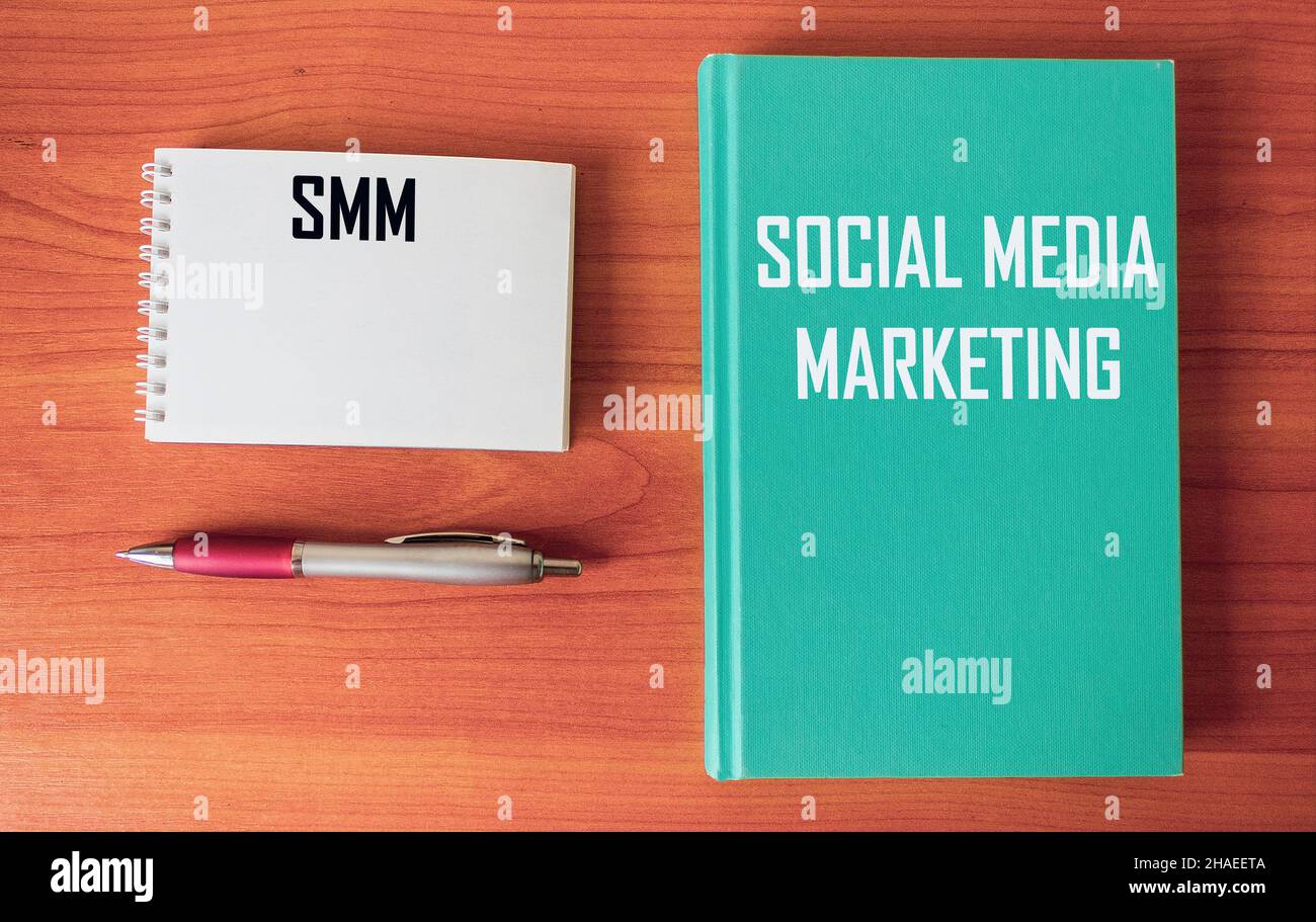 SMM text - MARKETING SUI SOCIAL NETWORK su un tavolo da ufficio con penna e blocco note. Foto Stock