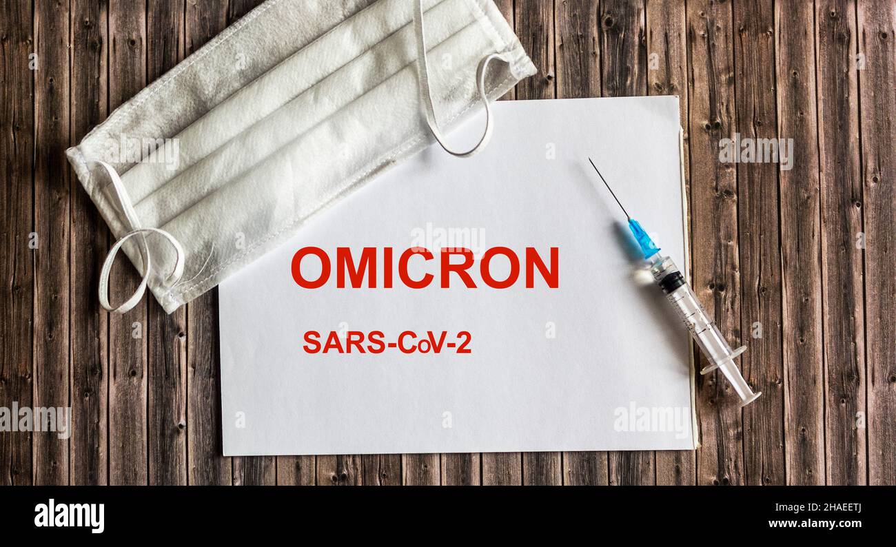 parola omicron su blocco note con maschera e vaccino corona virus. Omicron è un nuovo tipo di virus corona proveniente dal Sudafrica, denominato B.1.1.529. Foto Stock
