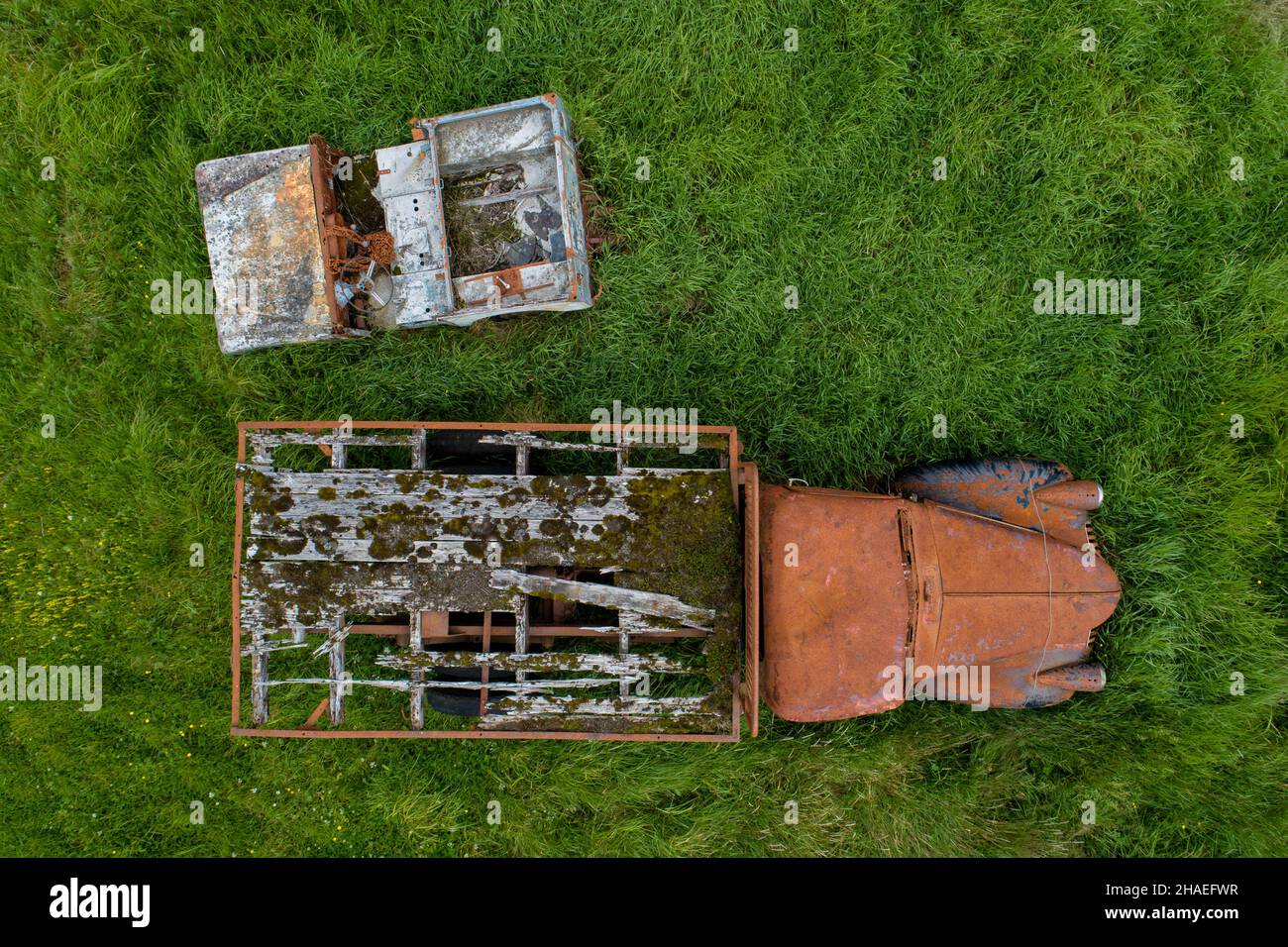 Uccelli vista occhio di un vecchio rovinato e arrugginito auto vecchie in piedi abbandonati in erba alta Foto Stock