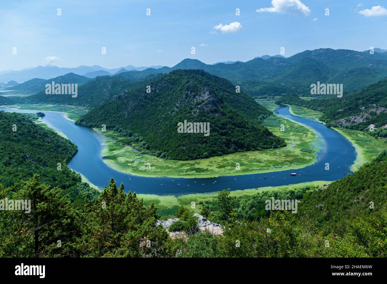 Vista sul fiume Crnojevica, Lago Skadar, Montenegro. Un luogo dove il fiume si piega intorno alla montagna verde. Foto Stock