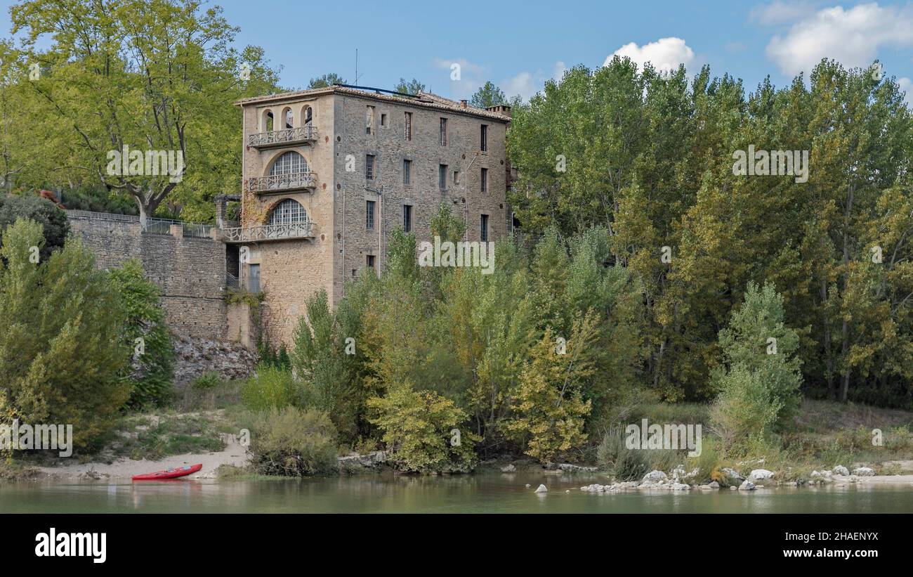 vista su un fiume in kayak sul lato di un fiume con un alto edificio quadrato costruito in pietra Foto Stock