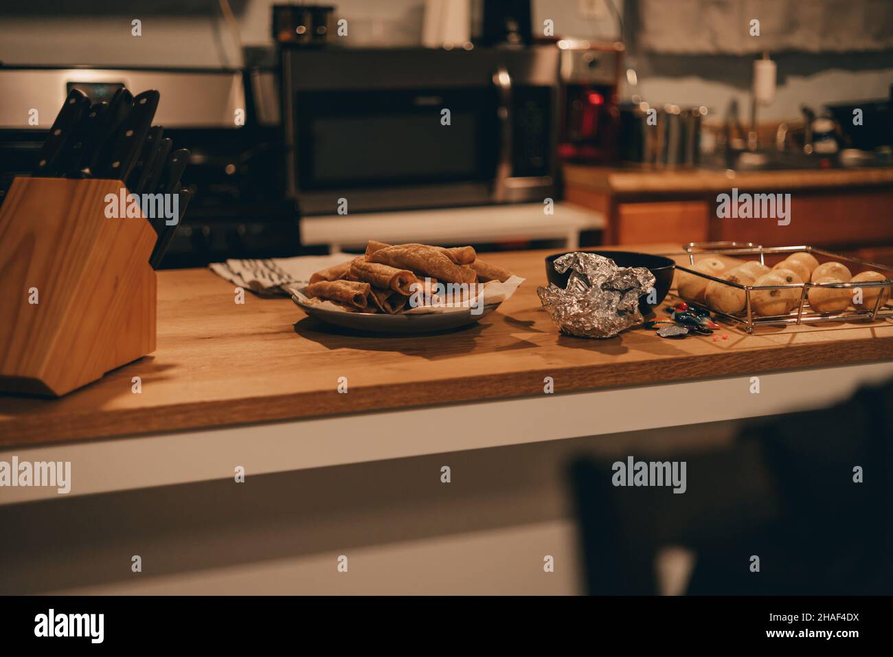 Un tavolo da cucina in legno con coltelli e cibo Foto Stock