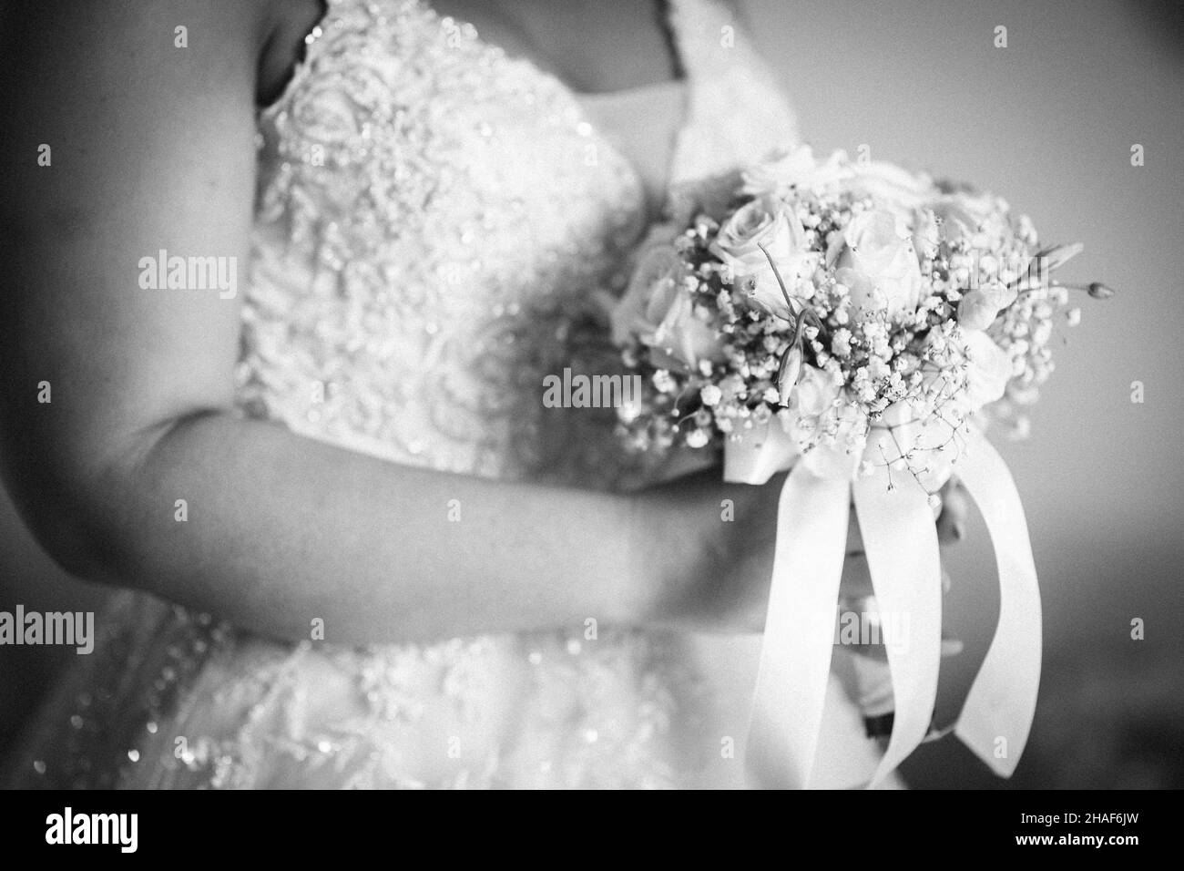 La sposa indossa il suo abito bianco e tiene il suo bouquet nuziale - pronto per la sua cerimonia nuziale Foto Stock