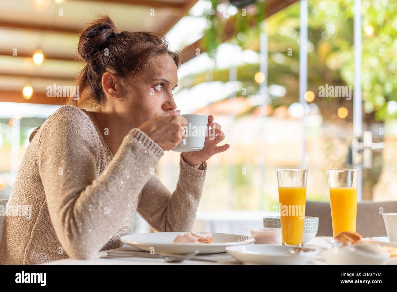 Donna che fa colazione in una sala da pranzo dell'hotel. Foto Stock