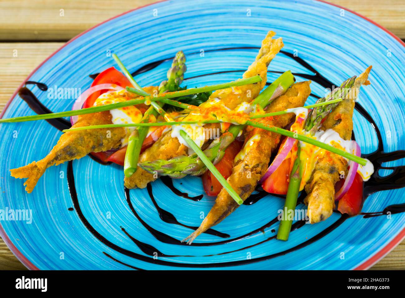 Alici fritte in pastella servito con salsa allo zenzero, pomodori, asparagi, cipolla e erba cipollina Foto Stock