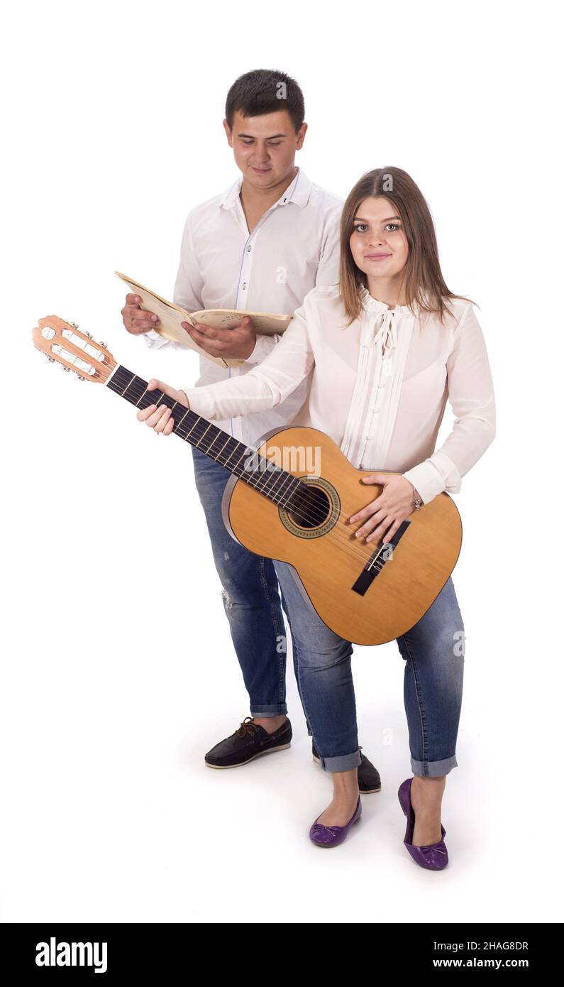 persone e musica. Donna e uomo incinta in camicie bianche e jeans con chitarra su sfondo bianco Foto Stock