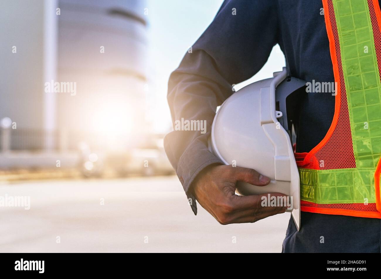 Costruzione ingegnere che tiene elmetto, tecnico che tiene elmetto, architettura di lavoro con elmetto di sicurezza Foto Stock