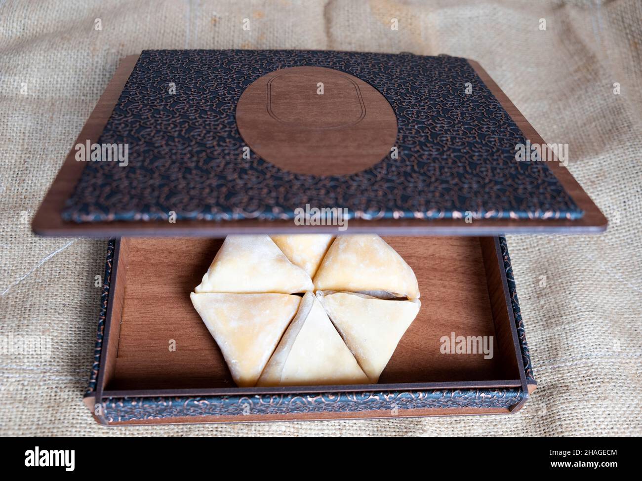 pestil, polpa di frutta secca, pestil turco esagonale in un'antica scatola di legno su tessuto di iuta da vicino dalla parte superiore Foto Stock