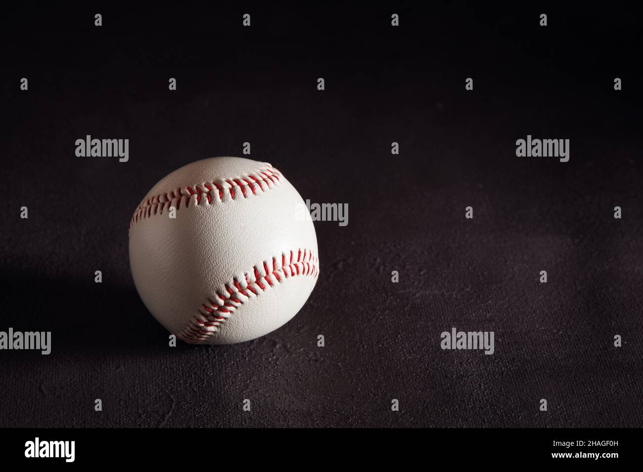 Palla da baseball su sfondo marrone scuro con spazio copia. Foto Stock