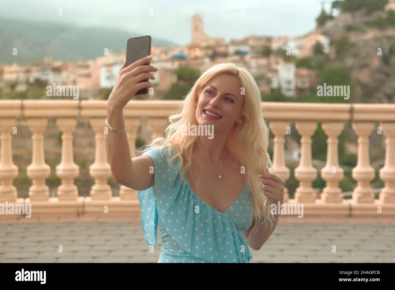 Bella donna bionda nel suo 40s prendendo selfie Foto Stock