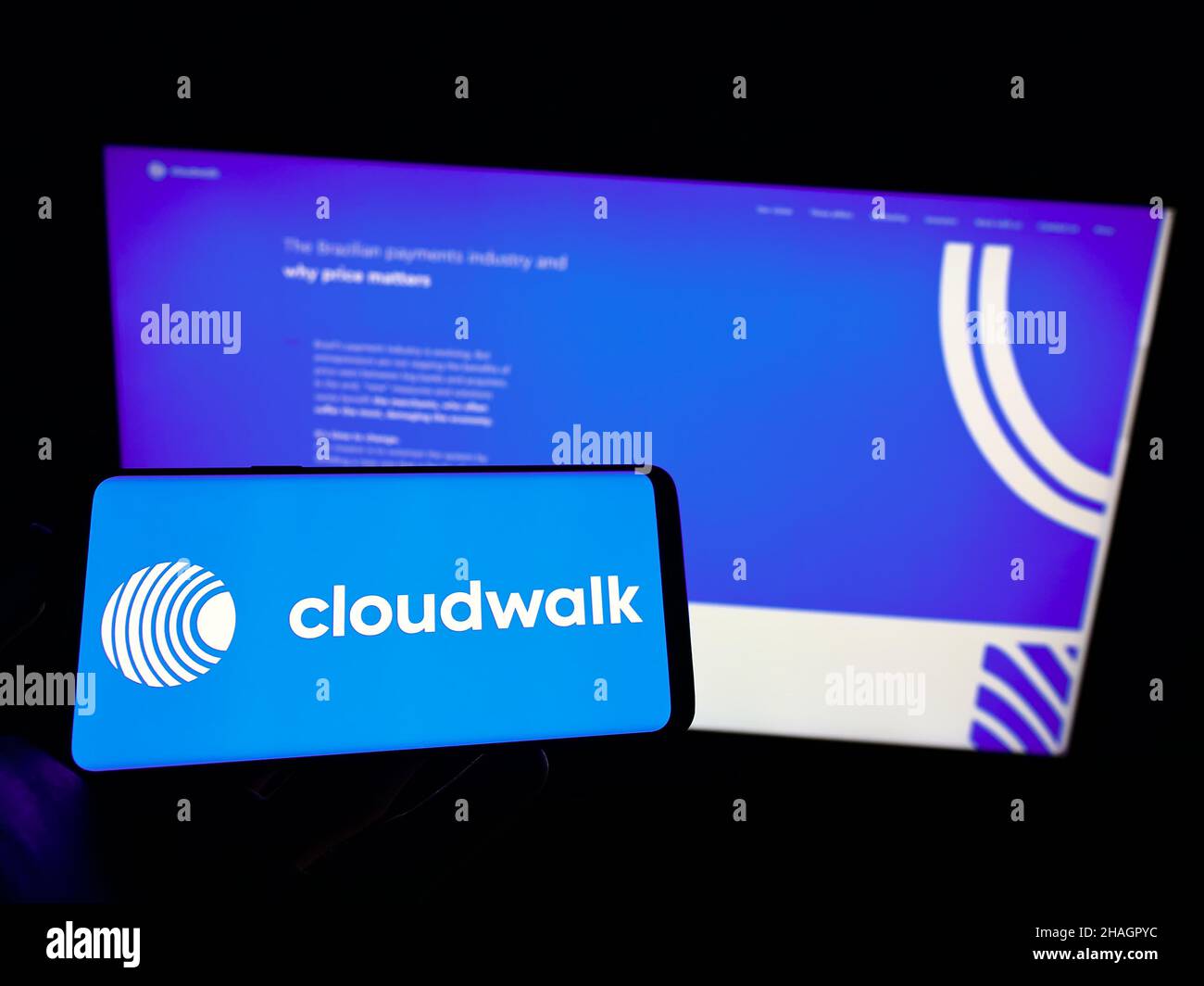 Persona che tiene il cellulare con il logo della società di pagamento brasiliana CloudWalk Inc. Sullo schermo di fronte al sito web aziendale. Mettere a fuoco sul display del telefono. Foto Stock