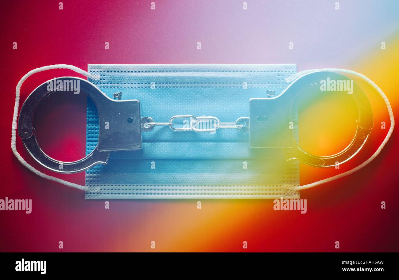 Manette appoggiate su una maschera chirurgica con l'arcobaleno. Foto Stock