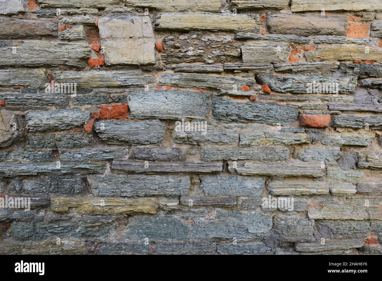 La tessitura della pietra, posta sulla parete, di forme e sfumature diverse per l'intera cornice Foto Stock