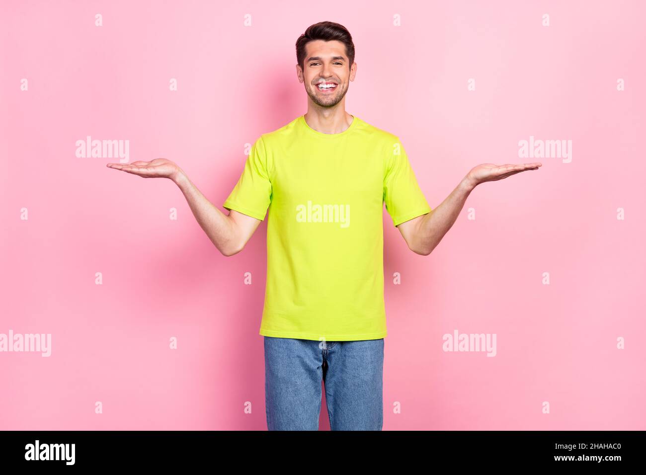 Foto ritratto uomo brunetto indossando luminosa t-shirt a confronto spazi vuoti isolato colore rosa pastello sfondo Foto Stock