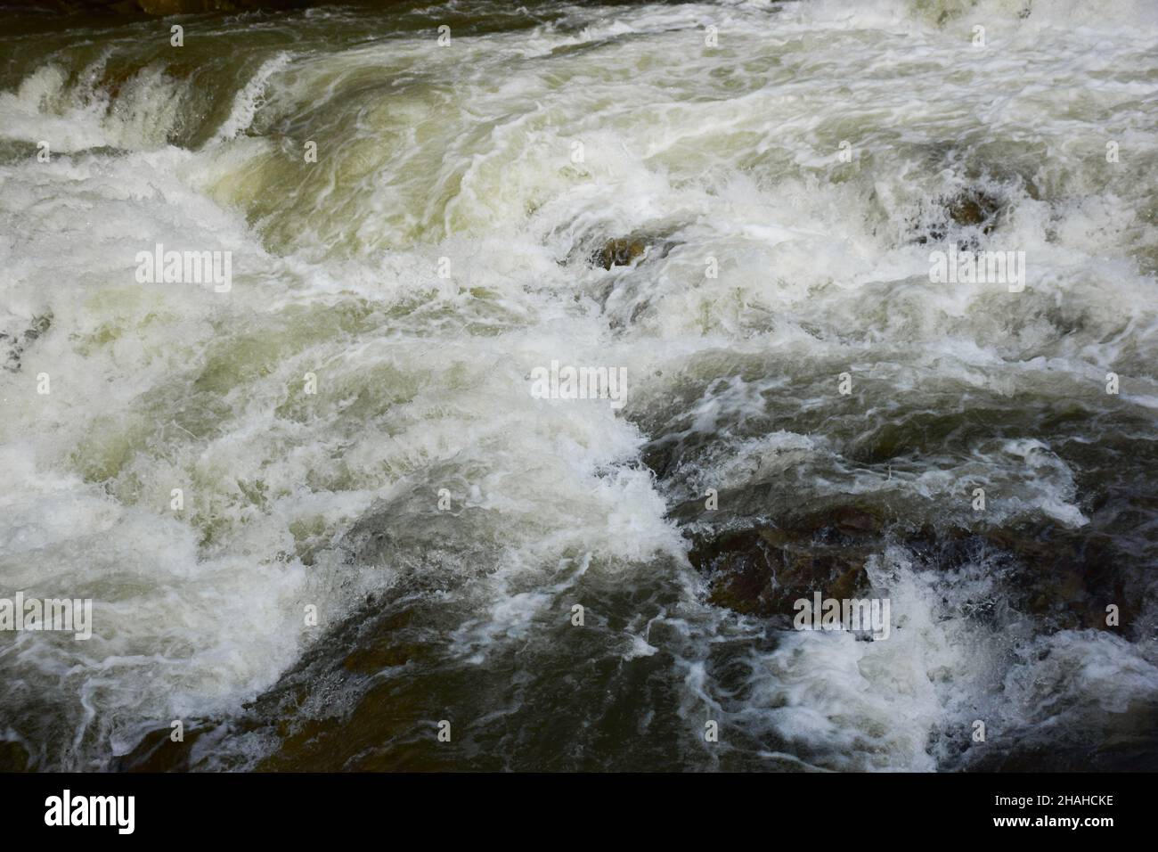 Un flusso tempestoso di acqua schiumosa sulla cascata per l'intera cornice Foto Stock