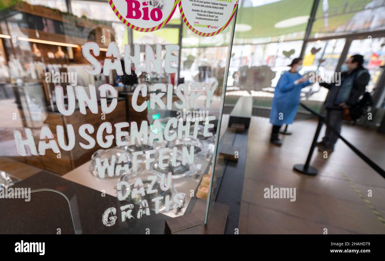 Stoccarda, Germania. 13th Dic 2021. Un dipendente di un centro di test di Corona in una gelateria del centro prende un campione di saliva da uomo. Credit: Marijan Murat/dpa/Alamy Live News Foto Stock