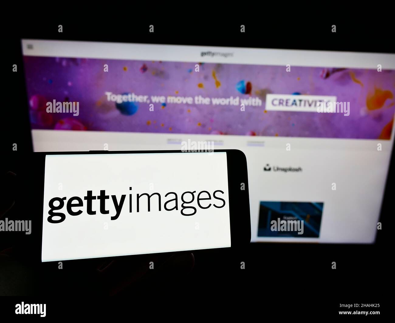 Persona che tiene il cellulare con il logo del fornitore di foto di scorta Getty Images Inc. Sullo schermo di fronte alla pagina web dell'azienda. Mettere a fuoco sul display del telefono. Foto Stock