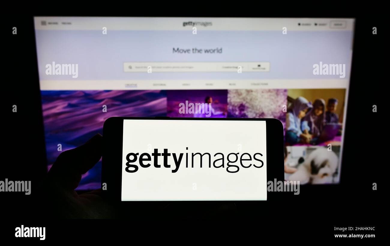 Persona che tiene lo smartphone con il logo del fornitore di foto di stock Getty Images Inc. Sullo schermo di fronte al sito Web. Mettere a fuoco sul display del telefono. Foto Stock
