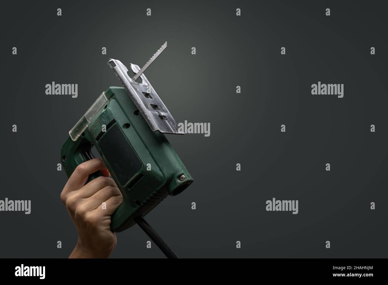 Seghetto alternativo tenuto da una mano - isolato su sfondo neutro Foto Stock