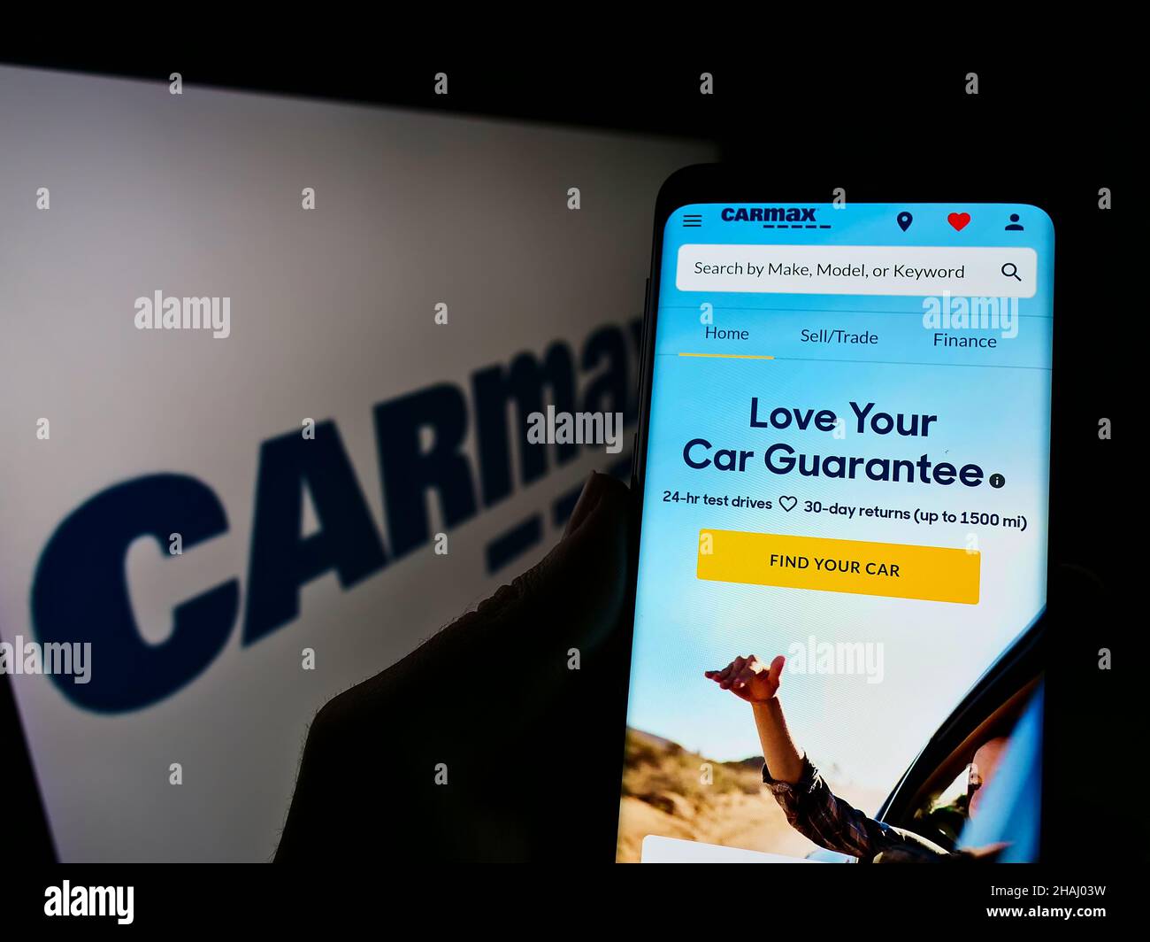 Persona che detiene il cellulare con il sito web del rivenditore di veicoli USA CarMax Business Services LLC sullo schermo con il logo. Concentrarsi sul centro del display del telefono. Foto Stock