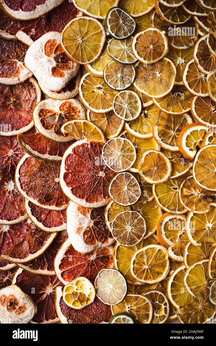 Fette di agrumi secchi, arancio, pompelmo e lime, preparando per le ghirlande di agrumi naturali per decorazione di vacanza, solstizio d'inverno, decoro yule Foto Stock