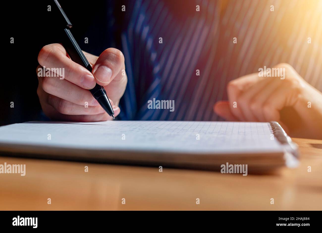 Primo piano mani di preparazione per le lezioni e lezioni accademiche presso la scrivania in legno con notebook e penna scrittura. Foto Stock