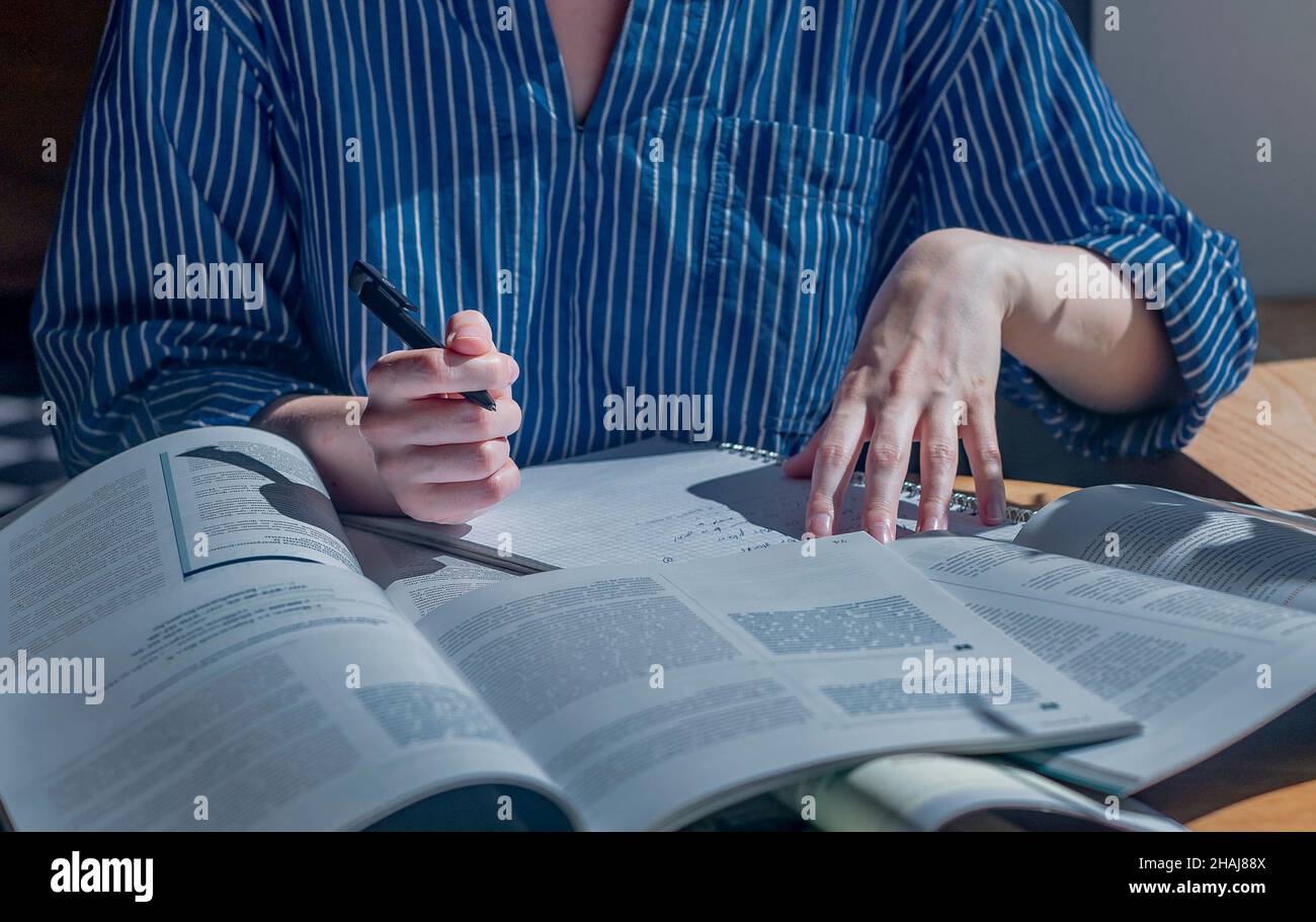 Minsk, Bielorussia - Ottobre 22 2021 Lotto di libri e libri di lavoro su scrivania in legno in caffetteria o biblioteca. Concetto di ricerca e ricerca di risposte nei libri di testo. Foto Stock