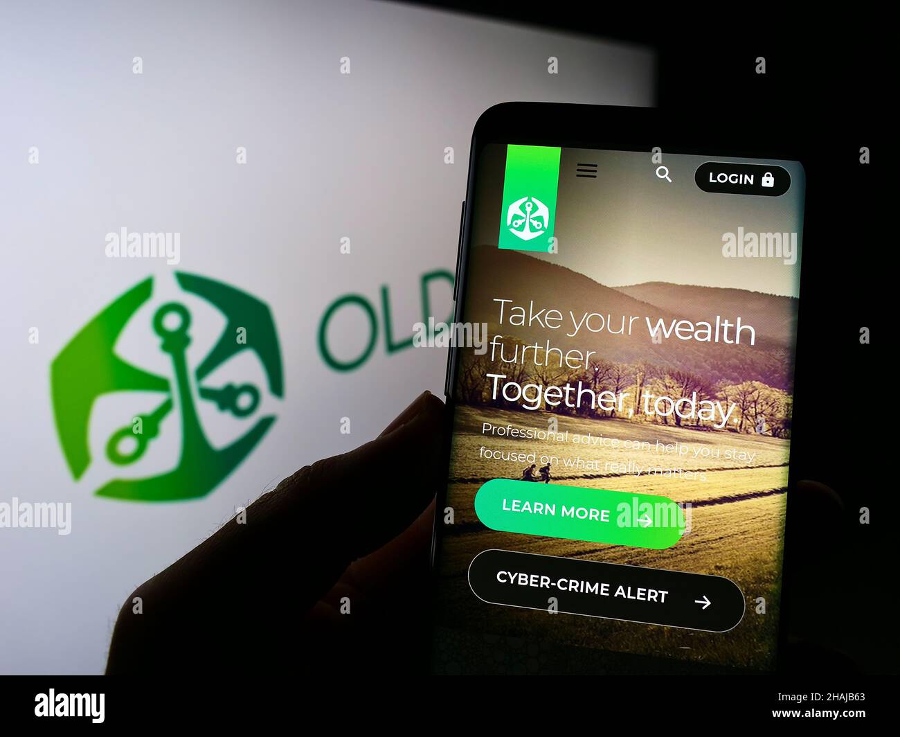Persona che detiene il cellulare con sito web della società finanziaria africana Old Mutual Limited (OML) sullo schermo con logo. Concentrarsi sul centro del display del telefono. Foto Stock