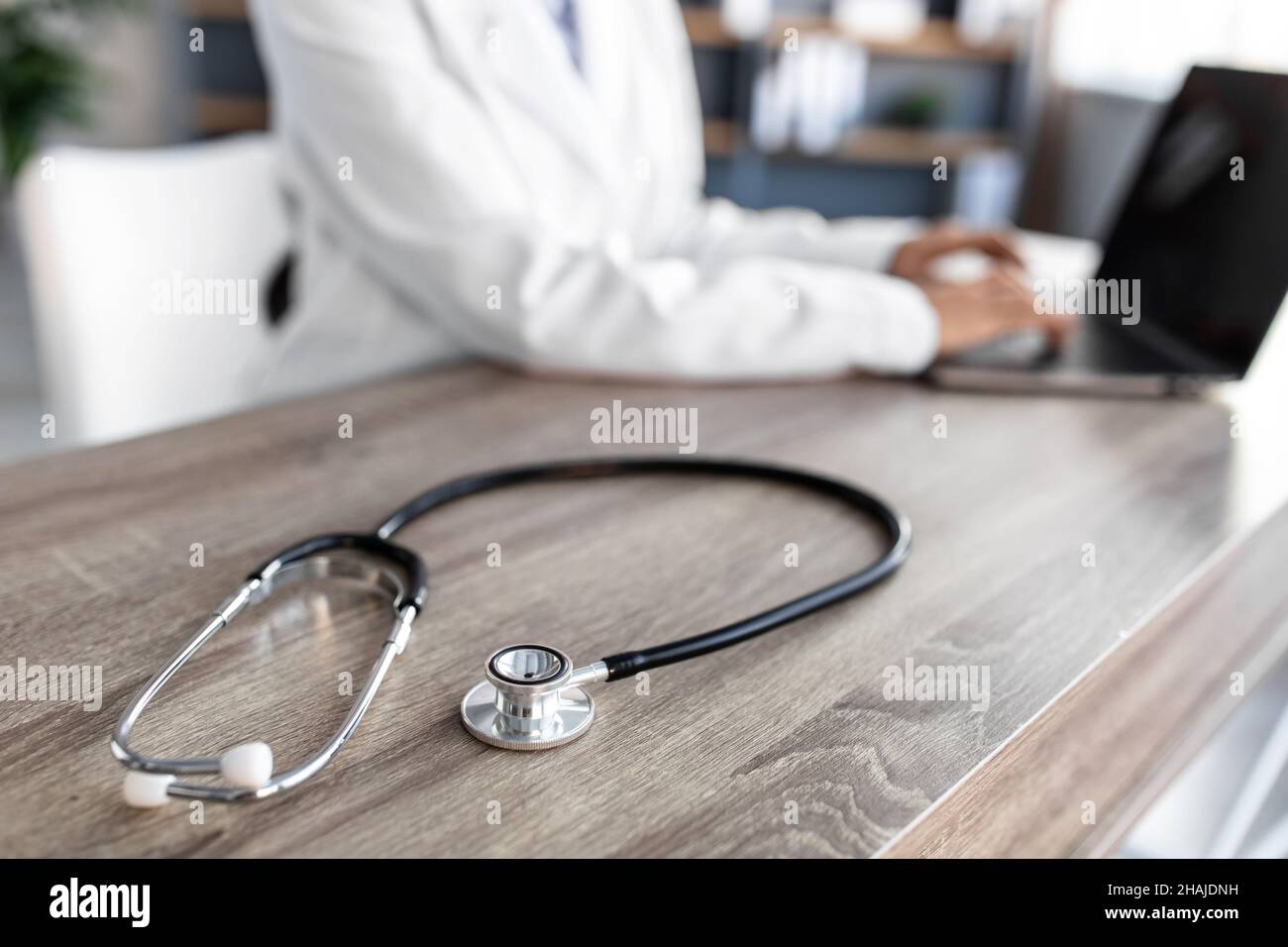 Stetoscopio e medico di base utilizzando il computer portatile alla scrivania in clinica di lavoro sul computer in ufficio, ritagliato Foto Stock
