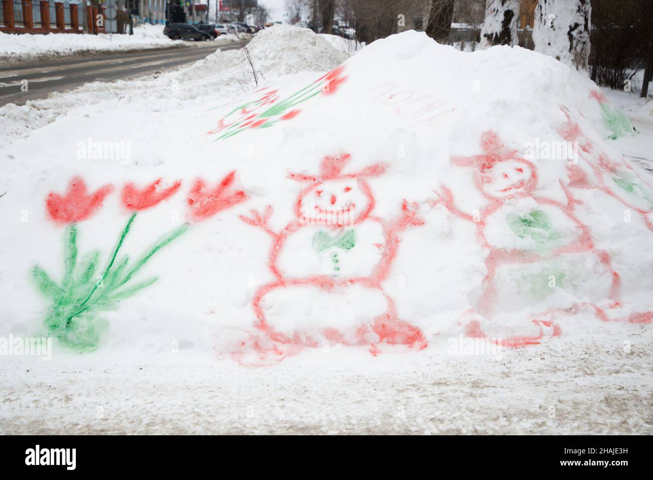 Disegno con pitture multicolore su neve, fiori dipinti e pupazzi di neve. Ciao inverno, ciao primavera. Giochi educativi invernali. Divertimento per tutta la famiglia.. Arrivederci Foto Stock