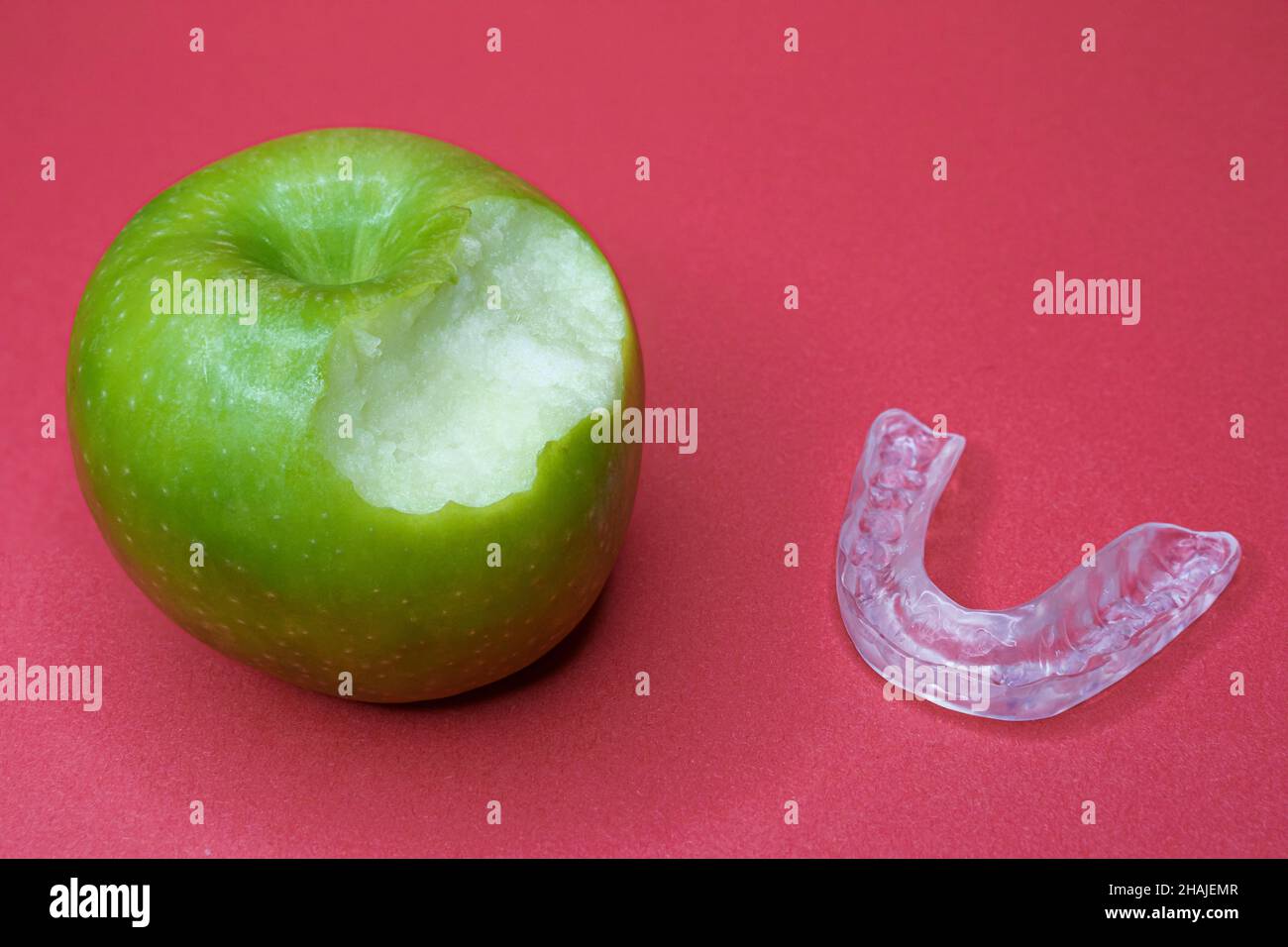 Mela verde con morso e una splint dentale Foto Stock