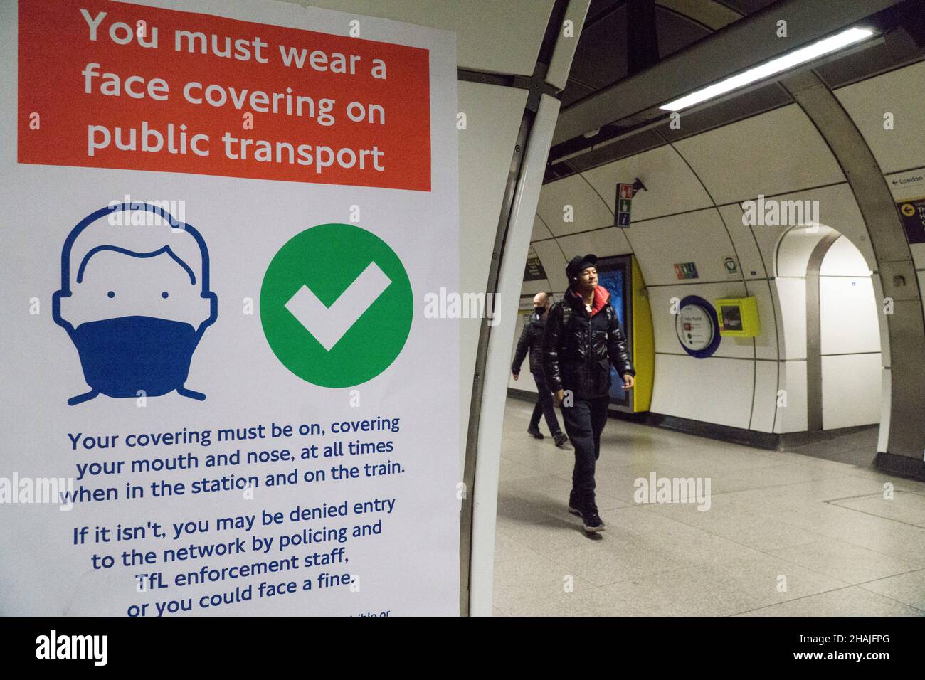 Londra, UK, 13 dicembre 2021: Alla stazione della metropolitana di London Bridge la maggior parte dei passeggeri obbedisce alle indicazioni che ricordano a tutti che le maschere facciali sono ora obbligatorie sui trasporti pubblici, a meno che non siano esenti da farmaci. Il footfall alle stazioni principali è stato giù 20% sulla settimana precedente dall'ordine del governo di lavorare da casa dove possibile. Anna Watson/Alamy Live News Foto Stock