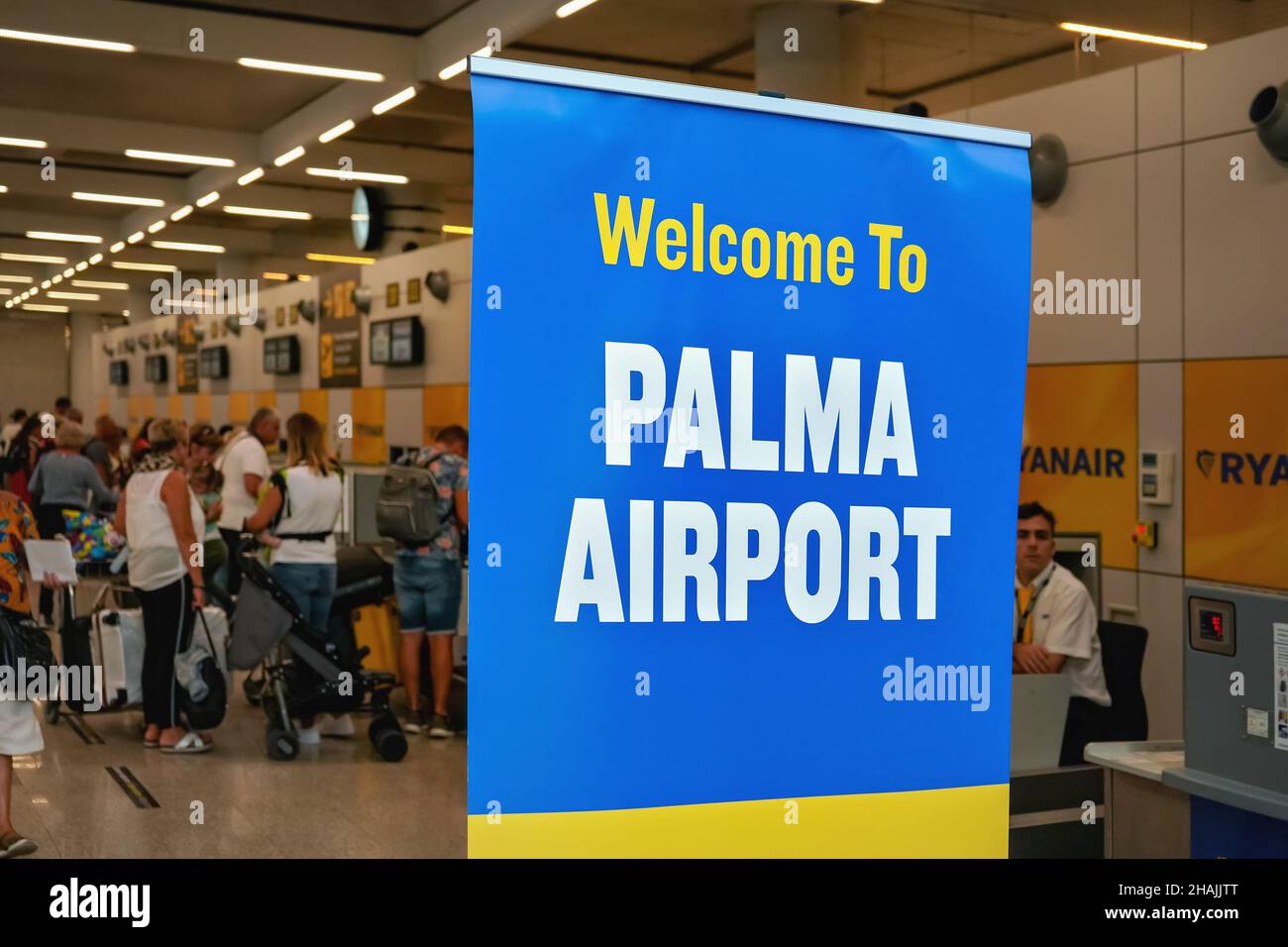 Palma, Spagna - 25 settembre 2019: Grande cartello di benvenuto con bandiera blu e bianca all'aeroporto di Mallorca, passeggeri offuscati in attesa al check-in banchi backgrou Foto Stock
