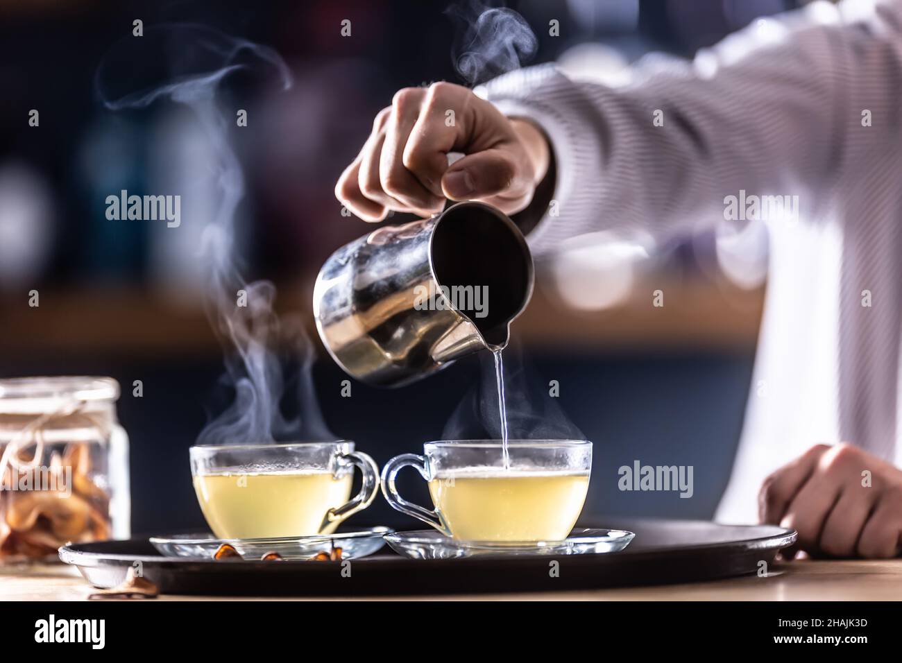Il barista versa il VIN brulé caldo o una bevanda invernale a base di whiskey Teddy caldo. Foto Stock