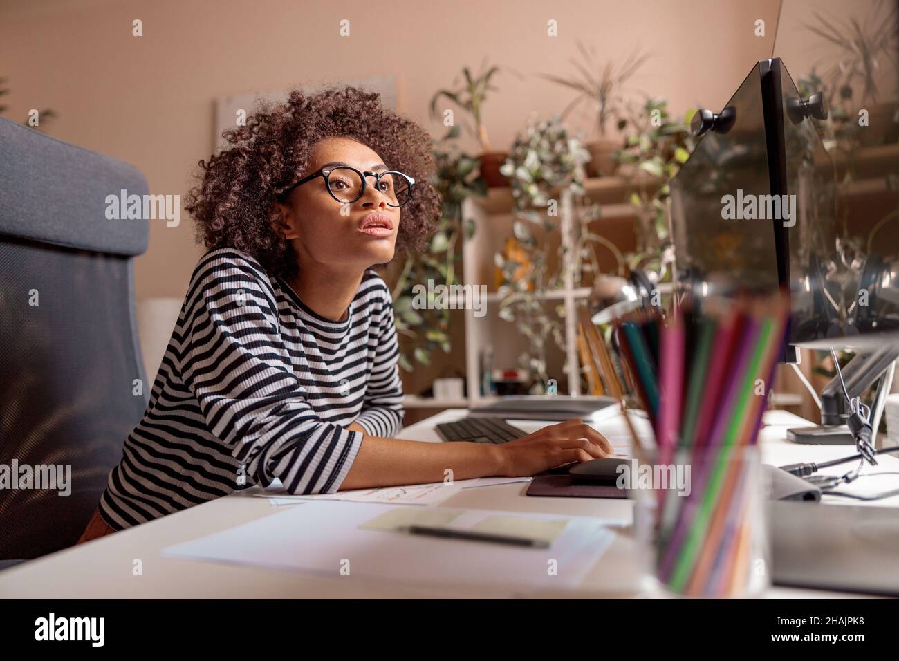 Giovane donna multietnica che usa il computer a casa Foto Stock