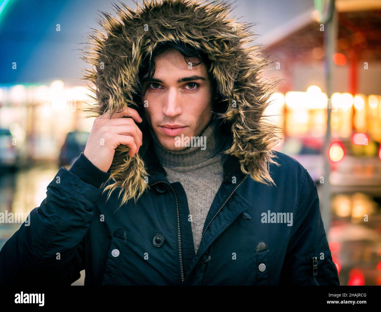 Uomo che cammina lungo la strada piovosa con cappotto Foto Stock