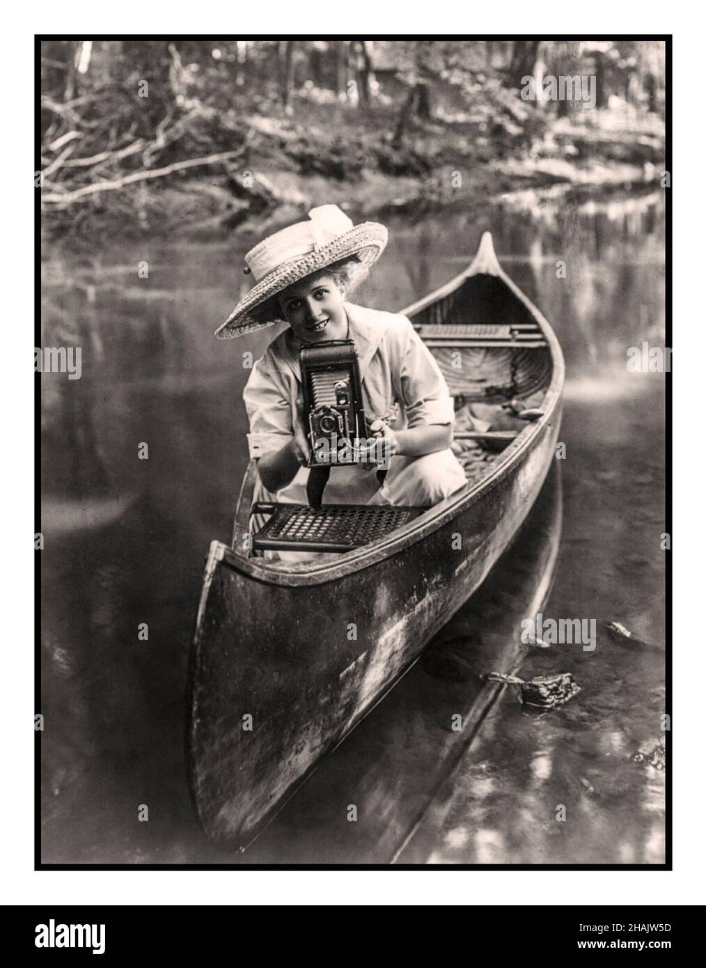 Vintage lifestyle advertising 1900s Donna all'aperto in canoa sul fiume puntamento ultima fotocamera KODAK soffietto pieghevole a rullo con scatto otturatore a bulbo d'aria. Fotocamere portatili una rivoluzione fotografica. Pubblicità Fotografia mostra giovane donna seduta in canoa puntamento di una fotocamera a soffietto pieghevole c1909 telecamere--1900-1910 Fotografi--1900-1910 - Fotografia--1900-1910 Donne--1900-1910 - Canoes--1900-1910 stampe fotografiche--1900-1910. Foto Stock