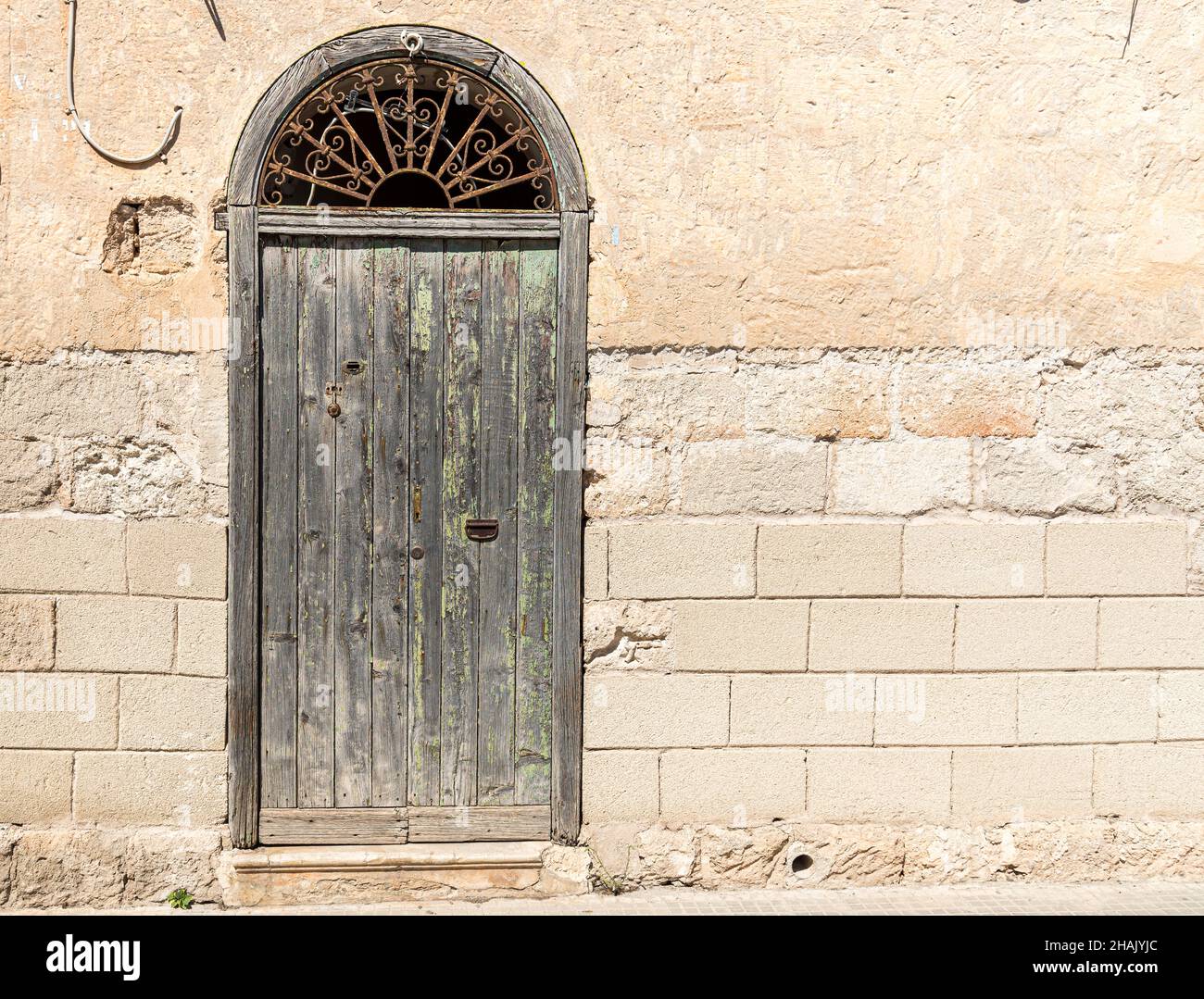 Antica porta in legno della tipica antica casa in pietra mediterranea in Sicilia. Foto Stock