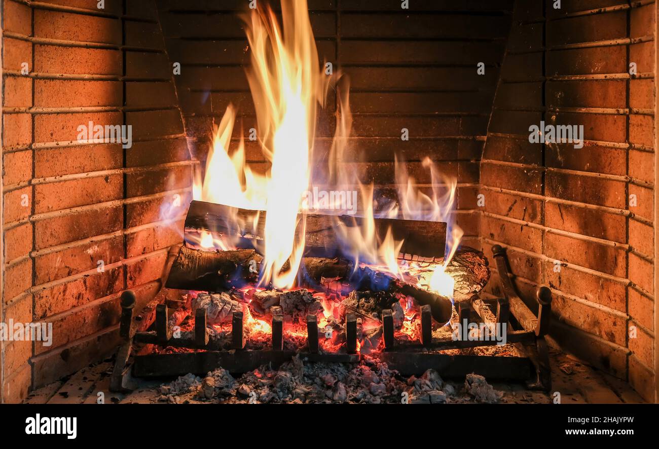 Natale, caminetto accogliente. Legna da ardere di tronchi, mattoni di fuoco sfondo, relax e casa calda interni, vacanze invernali Foto Stock